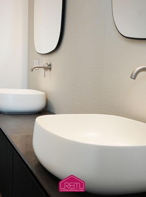 Bagno privato con un rivestimento ceramico in color gesso 