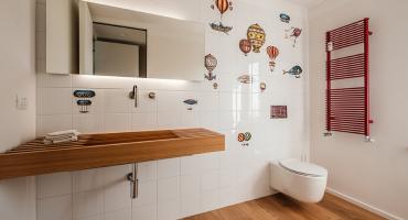 Bagno con piastrelle dal design giocoso e lavabo a doghe di legno