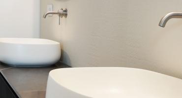 Bagno privato con un rivestimento ceramico in color gesso 