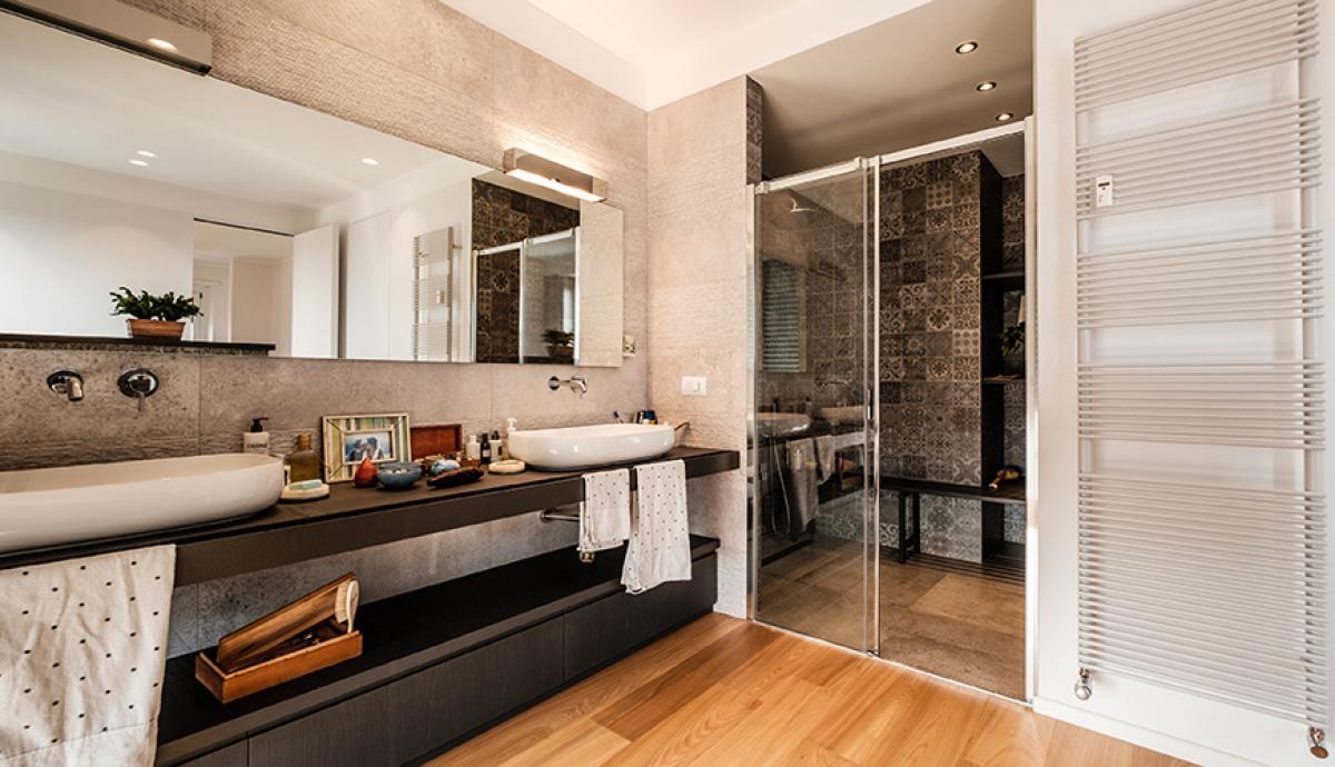 Bagno di tendenza con rivestimenti in legno e piastrelle, vasca idromassaggio e ampia doccia