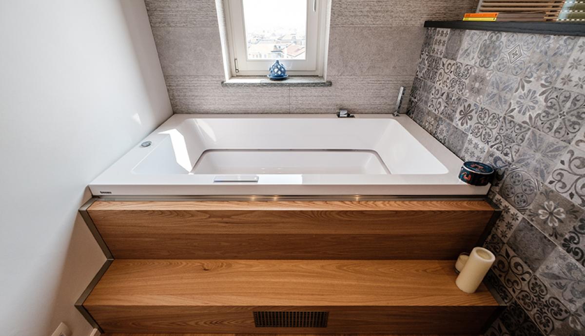 Bagno di tendenza con rivestimenti in legno e piastrelle, vasca idromassaggio e ampia doccia